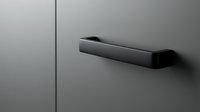 Matte black modern door handle on a sleek gray surface, showcasing minimalist design for interior architecture and home decor projects.