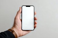 Male hand holding modern smartphone with blank white screen mockup for app presentation and digital marketing campaigns.