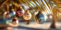 Elegant Christmas ornaments hanging from golden palm leaves, creating festive tropical holiday atmosphere with soft bokeh background.