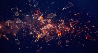 Dramatic glass explosion with flying fragments and bright orange sparks against dark blue background for dynamic design projects.