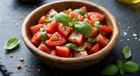 Fresh tomato salad with basil and cheese in wooden bowl on dark slate background for healthy Mediterranean cuisine and cooking recipes.