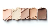 Crushed makeup foundation samples in nude and beige tones arranged in row showing color palette for cosmetic products.