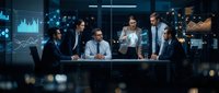 Diverse business team analyzing financial data with holographic charts and graphs in modern office meeting room for strategic planning.