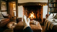 Cozy living room with crackling fireplace, comfortable seating, and warm atmosphere for relaxation and home comfort during cold winter evenings.