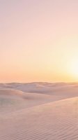 Serene desert landscape at sunrise with rolling sand dunes, soft golden light, and pastel sky. Ideal for travel, nature, and wellness design projects.