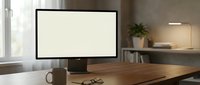Modern workspace with blank computer monitor on wooden desk in contemporary office interior for mockup and design presentations.