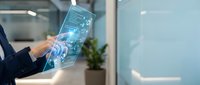 Businessman holding transparent digital tablet with holographic interface and data visualization in modern office environment for technology and innovation concepts.