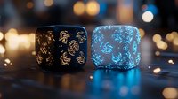 Two decorative cylindrical candle holders with intricate cut-out patterns creating warm golden and cool blue ambient lighting effects against bokeh background.