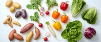 Fresh organic vegetables including colorful bell peppers, leafy greens, potatoes and radishes arranged on white background for healthy cooking and nutrition.