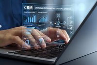 Professional using laptop with CRM customer relationship management dashboard displaying analytics charts and marketing automation interface.