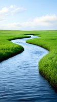 Meandering river flows through vibrant green grassland under soft cloudy sky, creating natural curves and patterns in peaceful landscape setting.