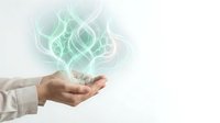 Businessman hand holding glowing green lotus flower hologram symbol representing mindfulness, meditation, wellness and spiritual growth concepts.