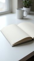 Open blank notebook on white desk with coffee mug and potted plant in bright workspace, suitable for journaling, writing, planning, education, and creative projects.