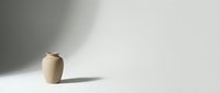 Minimalist beige ceramic vase with soft shadow on neutral background for modern home decor and interior design projects.