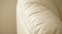 Close-up of soft cream-colored pillow with quilted stitching detail, showcasing texture and comfort for bedding, home decor, and lifestyle product photography.