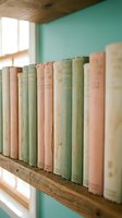 Row of vintage books with pastel covers on wooden shelf against mint green wall creating cozy reading nook atmosphere for home decor and literary themes.