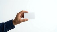 Hand holding blank white business card against neutral background, ready for branding and corporate identity design projects.