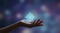 Hand holding glowing mystical compass symbol with spiritual energy against blurred cosmic background for meditation and guidance concepts.