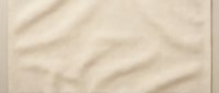 Soft beige fabric texture with natural wrinkles and folds, perfect for backgrounds, textile design, and creative projects requiring organic material surface.