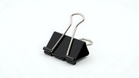 Black binder clip isolated on white background, office supply for organizing documents and papers, ready for design use.