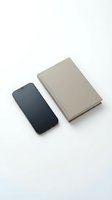 Modern smartphone and gray notebook on clean white background for business and productivity concepts.