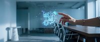 Businessman hand interacting with glowing digital factory and industrial automation icons in modern office conference room for manufacturing technology solutions.
