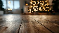 Rustic wooden table surface with blurred golden Christmas lights bokeh in background creating warm festive atmosphere, selective focus on wood grain texture.