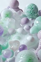 Abstract composition of soft pastel spheres and organic shapes in mint green, lavender and white with perforated surfaces floating in dreamy atmospheric space.