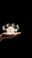 Hand holding glowing house model with floating currency symbols dollar euro yen representing real estate investment and global property market.
