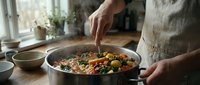 Person cooking healthy vegetable stir-fry in kitchen pan with fresh ingredients. Home cooking, meal preparation, nutritious food lifestyle concept.