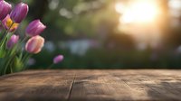 Fresh pink tulips against blurred garden background with rustic wooden table surface in foreground, golden sunlight creating dreamy spring atmosphere.