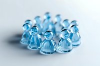 Translucent blue glass figures arranged in circle on white background, creating soft shadows. Minimalist composition shows unity and connection in business team concept.