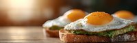 Sunny side up eggs on avocado toast with fresh herbs served on rustic wooden table. Morning breakfast composition with natural light and bokeh effect.