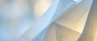 Abstract flowing white fabric layers creating soft ethereal waves with gentle lighting and translucent textures for modern design backgrounds.