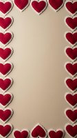 Red felt hearts with white stitched edges arranged as decorative border frame on beige background for Valentine's Day cards and romantic designs.