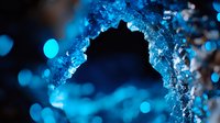 Frozen ice arch formation with bright blue bokeh lights in dark background creates magical winter atmosphere for seasonal designs and holiday cards.