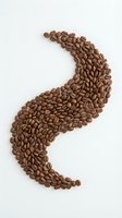 Roasted coffee beans arranged in curved S-shape on white background, isolated and ready for design use in beverage marketing, cafe branding, and coffee product packaging.