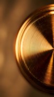 Copper metal surface with circular brushed texture and warm golden lighting creating industrial luxury aesthetic for premium design projects.