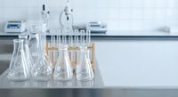 Clean laboratory glassware including beakers and flasks arranged on white counter in modern research facility for scientific experiments and analysis.