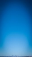 Clear blue sky gradient background with mountain silhouette horizon line for nature photography and outdoor adventure designs.