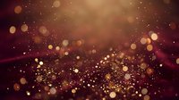 Sparkling burgundy and gold bokeh background with glittering particles and warm light effects for luxury holiday celebrations and festive designs.