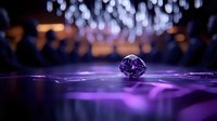 Sparkling purple diamond gemstone on reflective surface with bokeh lights background for luxury jewelry and precious stone concepts.