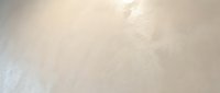Textured white and beige concrete wall surface with subtle light reflections and weathered finish, suitable for backgrounds, overlays, and design projects.