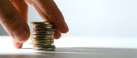 Hand stacking golden coins, symbolizing financial growth, savings, and wealth accumulation for business and investment concepts.