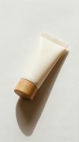 Eco-friendly cosmetic tube with wooden cap on neutral background for sustainable beauty and skincare product packaging design.