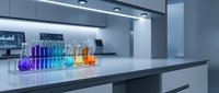 Colorful laboratory glassware with chemical solutions on modern lab bench. Scientific research equipment for experiments and analysis in contemporary laboratory setting.