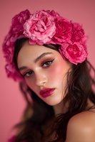 Young woman with pink rose crown against matching background, featuring glamorous makeup with fuchsia lips and rosy cheeks for fashion or beauty advertising.