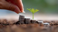 Growing plant sprout on stacked coins in soil, symbolizing financial growth and sustainable investment. Hand adding coin represents money management and wealth building.