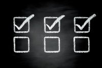 Chalk drawn checkboxes on blackboard with three checked and three unchecked boxes representing choices, tasks or survey options.