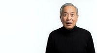 Senior Asian man with gray hair wearing black turtleneck sweater against white background, suitable for corporate, business, healthcare, and educational content.